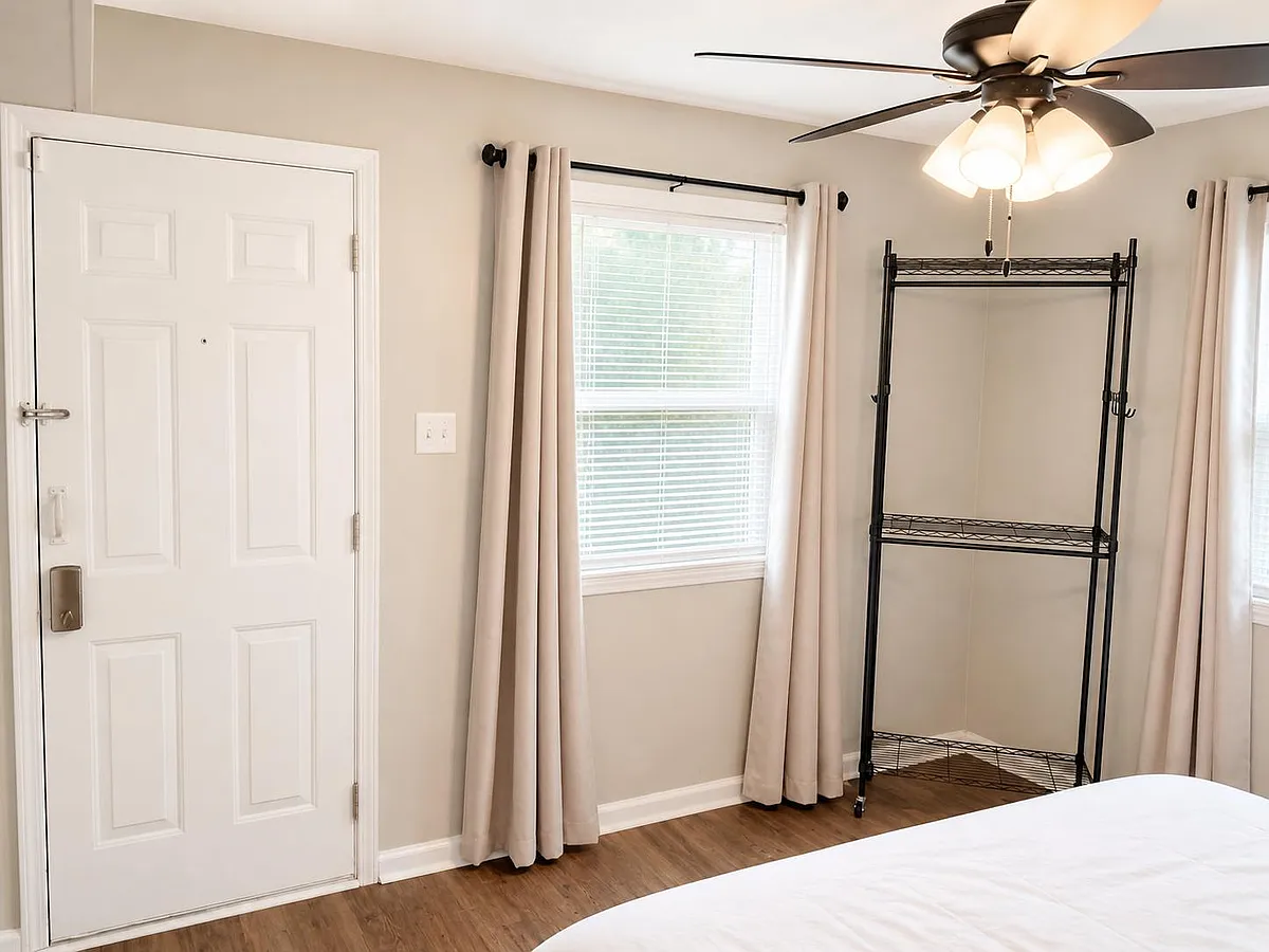 Bedroom with 2 large windows, block out drapes, ceiling fan with light, and a rolling open closet rack and private entrance. - White Plains Rd