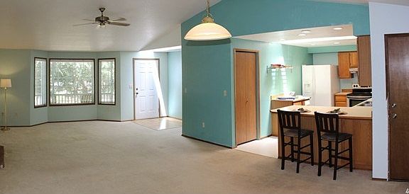 View of entry, living, dining and kitchen. Vaulted ceilings and bay window.