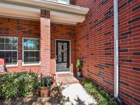 Covered front porch with bricked flooring welcomes you into this home.