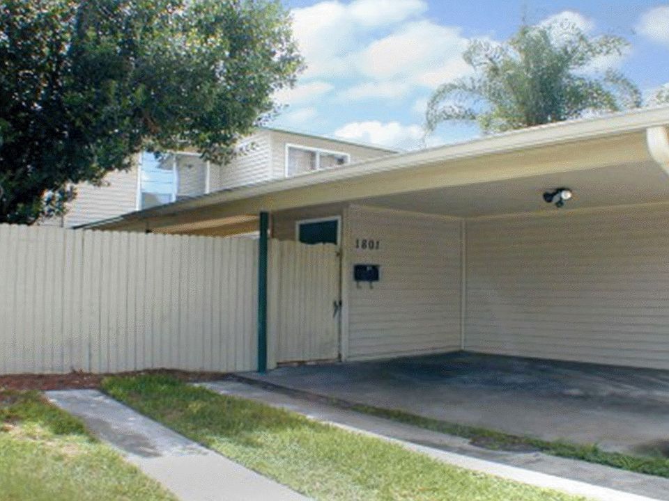 End Unit with Carport, fenced courtyard is landscaped with a waterfall pond
