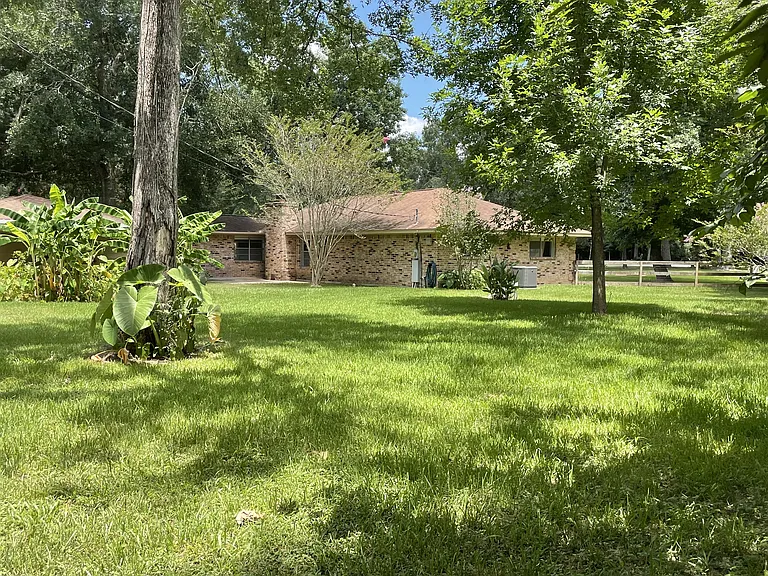 2/3 of an acre corner lot with privacy and space. Backyard looking toward house and garage.