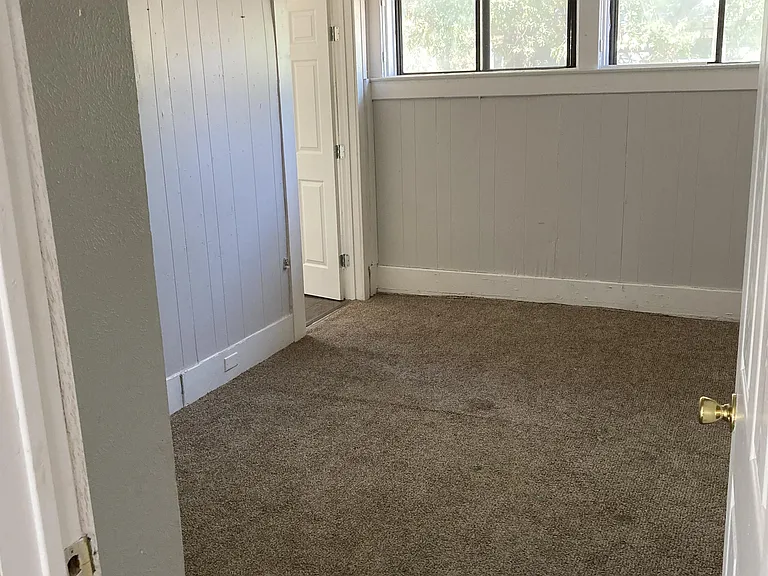 Bedroom 3 with its own closet, ceiling fan, and carpeting.