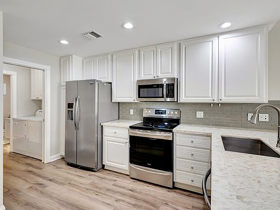 Quartz countertop kitchen w/ stainless steel appliances.