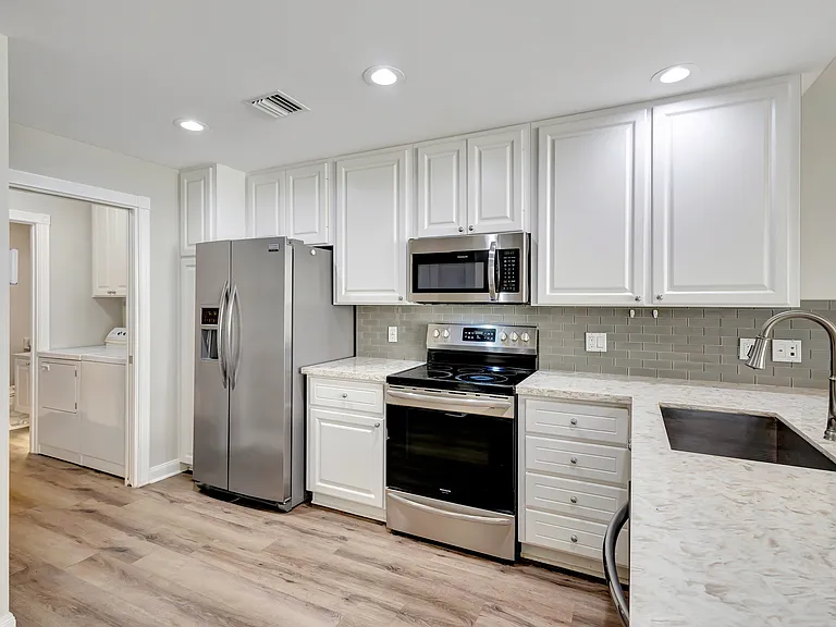 Quartz countertop kitchen w/ stainless steel appliances.