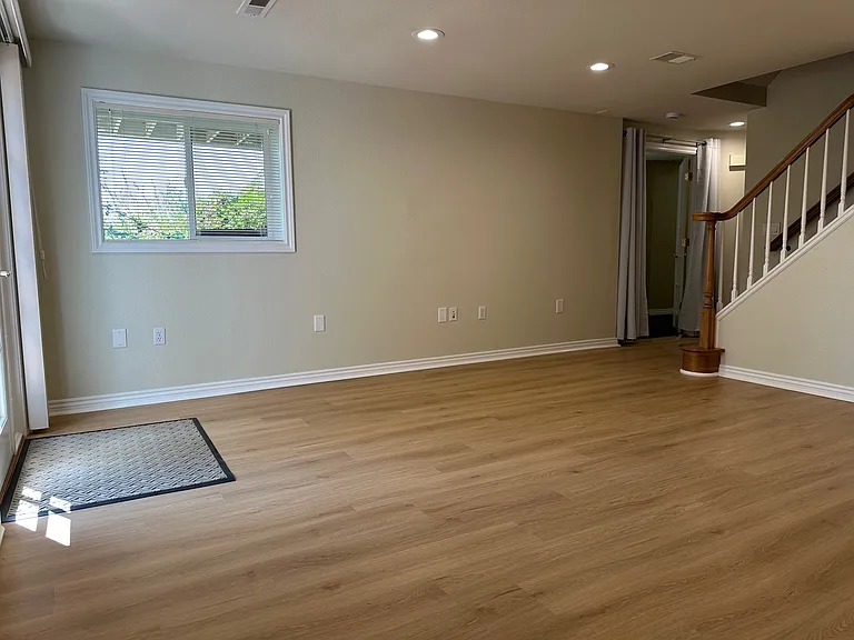 Looking from the corner of the main room toward the south bedroom and existing stairs to the upper floors. Bathroom is on the right and south bedroom door on the left. (Locked door at top. of stairs.)