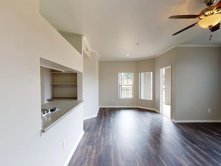 Apartment living room with wood-style flooring and patio or balcony in select homes.