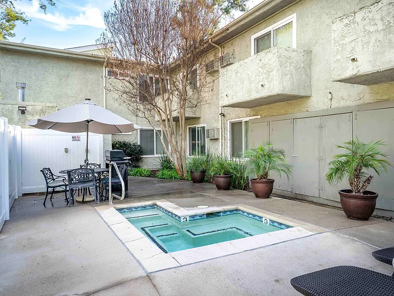 Spacious outdoor spa and BBQ area with lush greenery at the Excelsior Apartments in Studio City