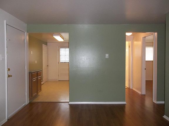 Living Room View (Front Door, Kitchen, Bedroom 2, Hallway to Bathroom)