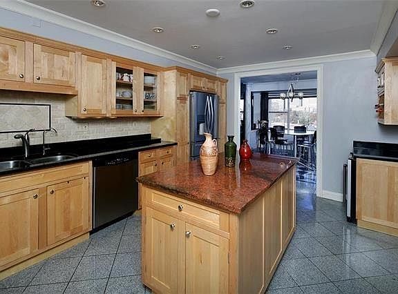 Kitchen view with polished stone floor. Wine refrigerator and wine racking on right side of photo
