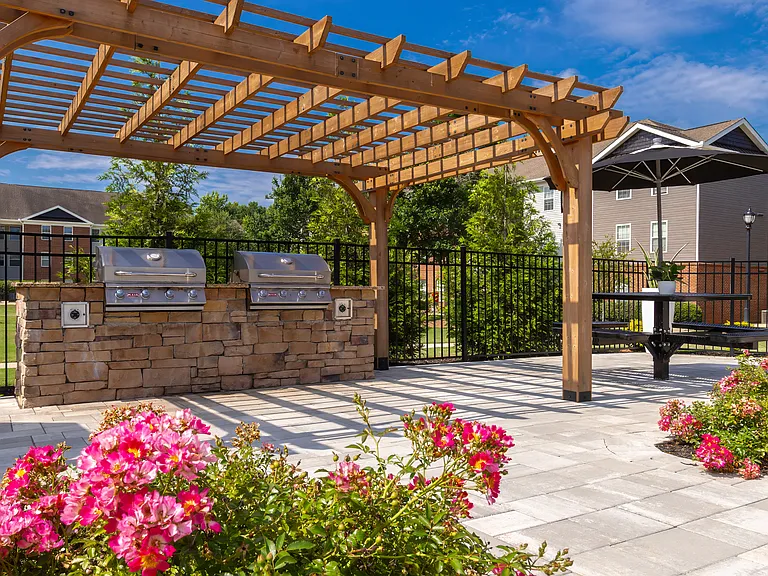 Enjoy beautifully landscaped walkways with wooden pergola shade and colorful flowering plants, professionally operated by Highlands Vista Group