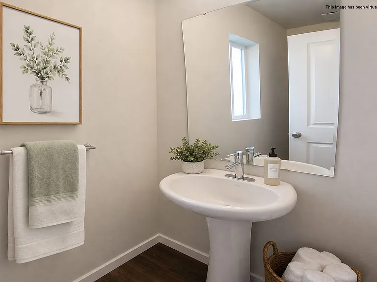 Convenient half bath on main level, virtually staged.