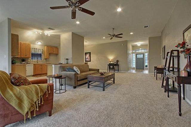 Living area featuring fireplace, and dual ceiling fans