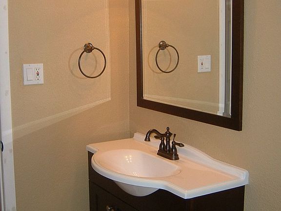 Bathroom with new vanilty, lighting, mirror, and tile.