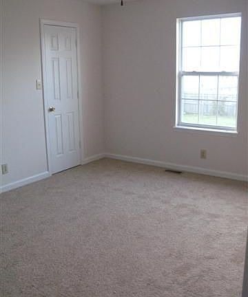 Master bedroom with new carpet, walk in closet and ceiling fan