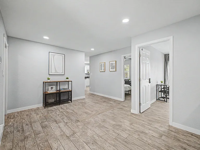 Open common area with wood-look tile floors, recessed lighting, and easy access to nearby bedrooms and the kitchen.