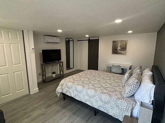 Spacious, well-lit bedroom with a comfortable queen-size bed.