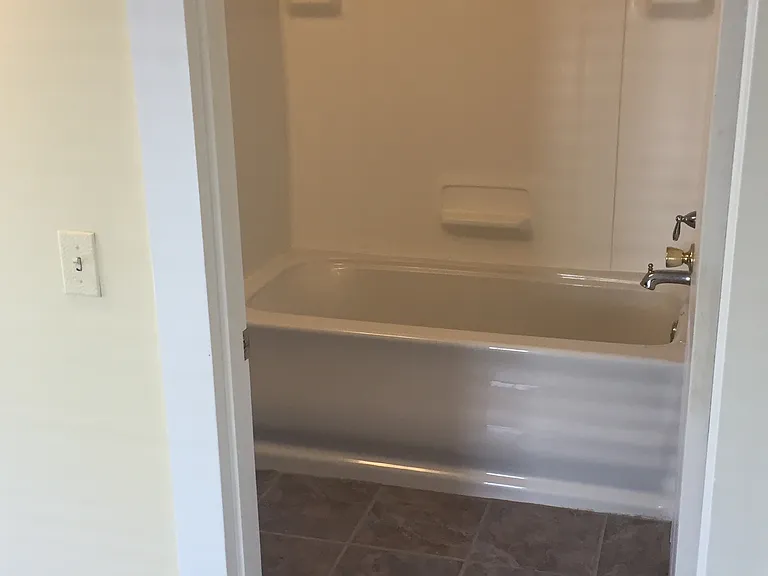 Bathroom with tile flooring; deep soaking tub with shower