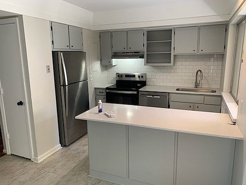 stainless steel appliances, quartz countertop, subway tile backsplash and pantry.
