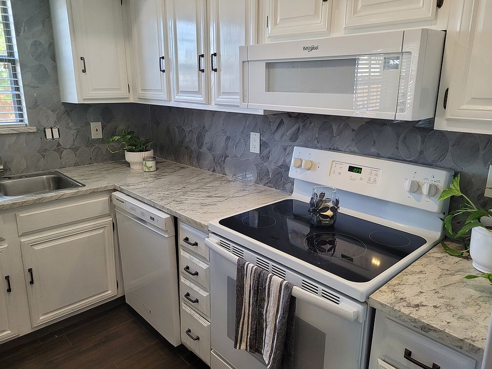 Freshly painted cabinets, new stone countertop and backsplash.