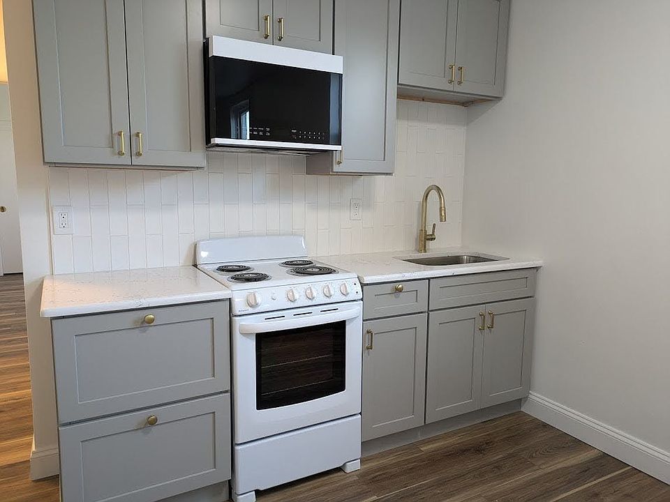 Kitchen with tile backsplash and quartz countertops.