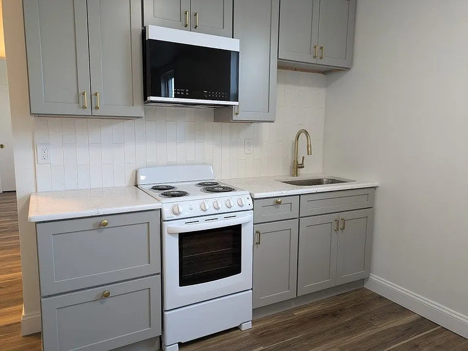 Kitchen with tile backsplash and quartz countertops.