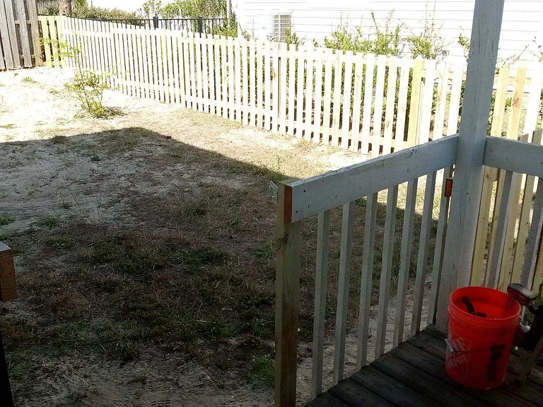 View of fence enclosure on right side with gate opening into the porch area