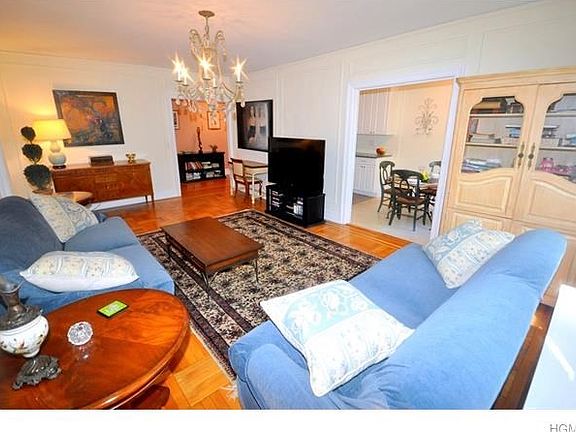Oversized living room has parquet floors picture and wall moldings and overlooks tree lined Garth Ro
