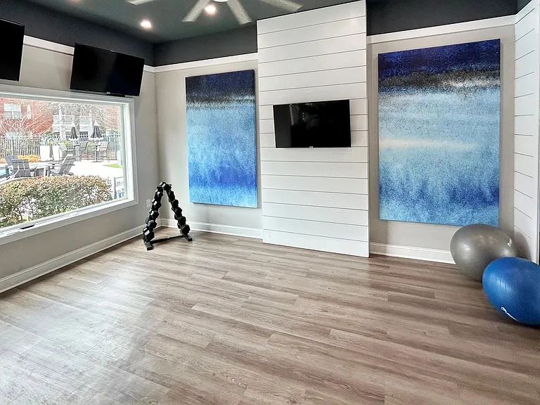 Find balance in our serene yoga studio, featuring a peaceful aesthetic, fitness balls, dumbbells, mirrored walls, and beautiful pool views.