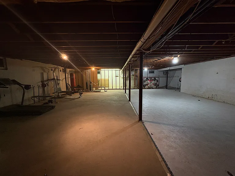 Basement with exercise equipment and skatable fake ice rink.