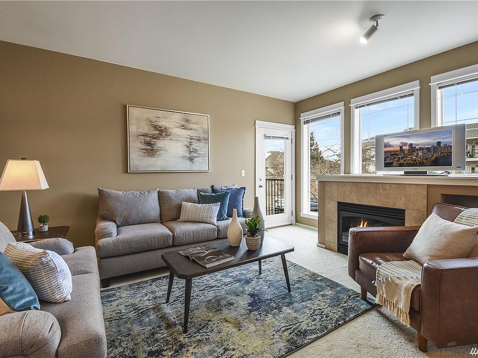 Spacious living room with bright windows, gas fireplace and built-in storage space.