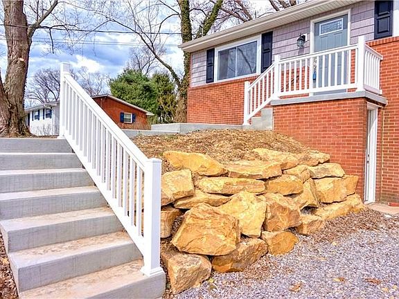 New concrete stairs/sidewalk and large boulders create an inviting impression!