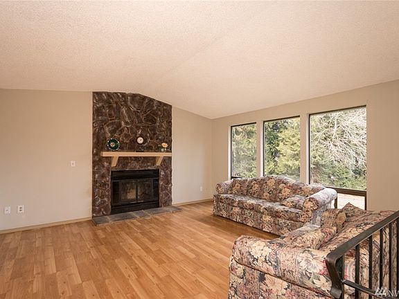 Large Living Room with Huge Windows for lots of Natural Lighting, Wood Fireplace, and Laminate Flooring.