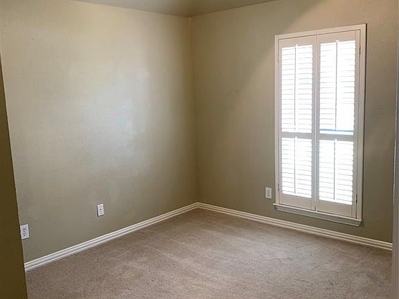 Unfurnished room featuring ceiling fan and carpet