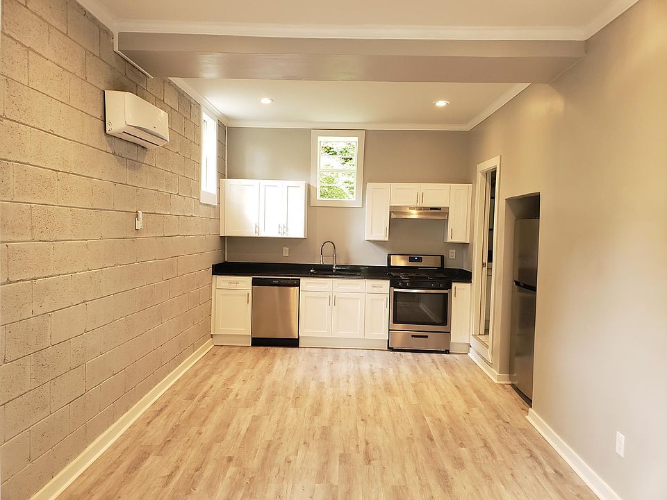Photo from front door entrance. 12-foot ceilings with an open floor plan living room, dining room, kitchen.