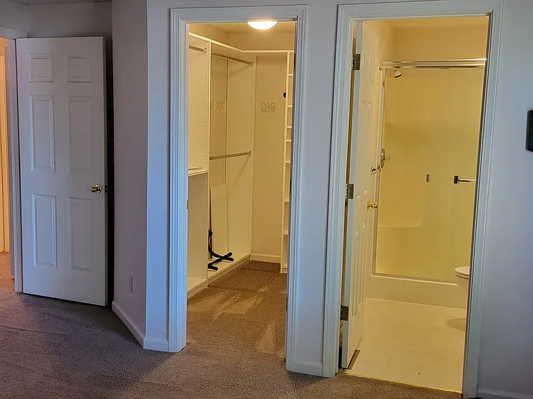 View of bathroom, walk in closet and hallway from inside master bedroom