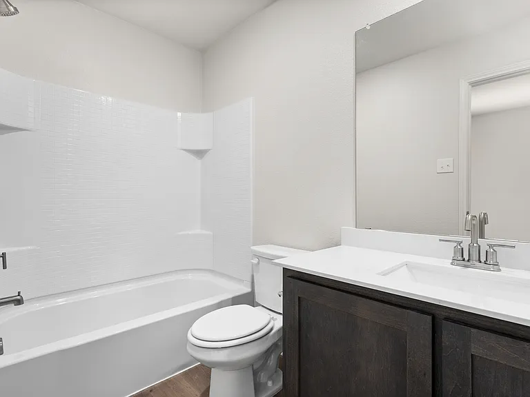 The secondary bathroom has a sprawling vanity and shower-tub combo.