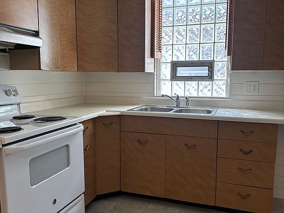 Kitchen with glass block window and new flooring throughout.