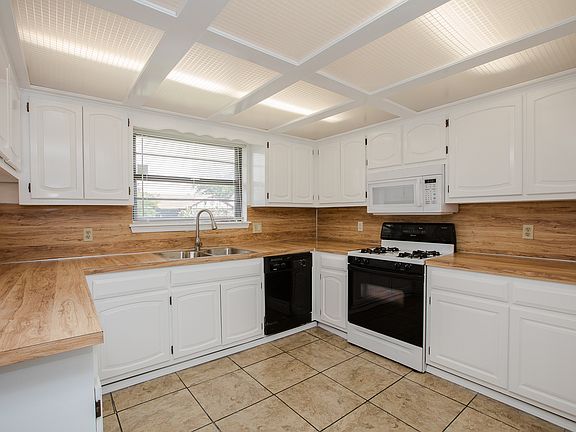 Updated Kitchen with tile floors, gas range, built-in microwave and new stainless steel double basin sink with single arm pull down faucet. 