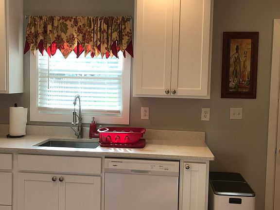 Kitchen window overlooks large backyard and driveway