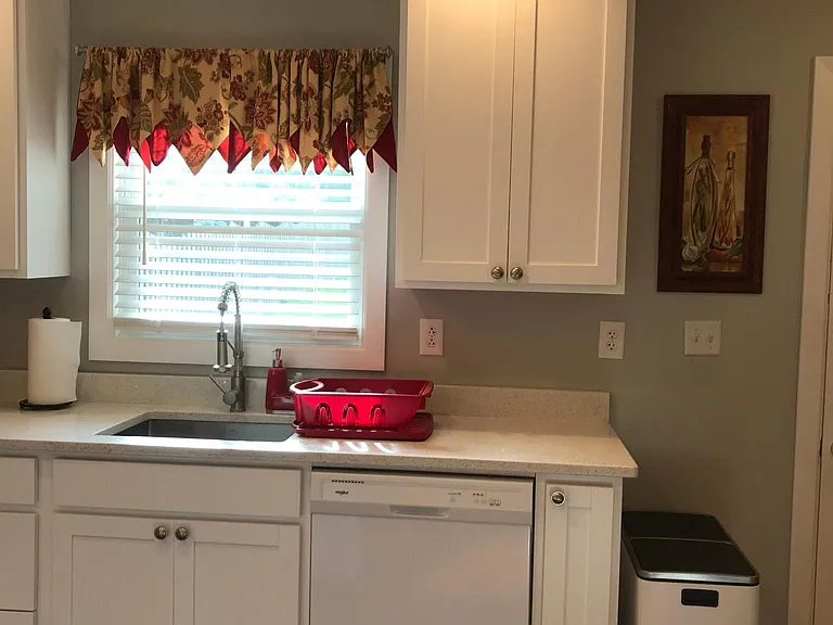 Kitchen window overlooks large backyard and driveway
