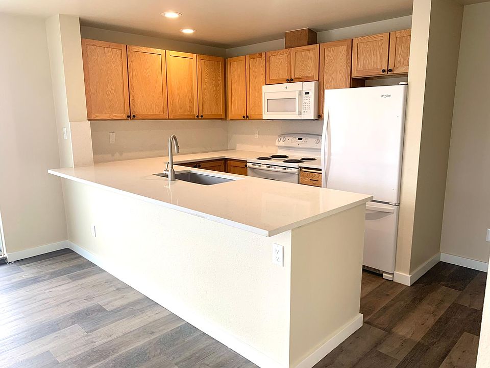 Kitchen with island and quartz countertops, deep sink, garbage disposal, dishwasher and bottom freezer. Island has room for bar stools or a bench.