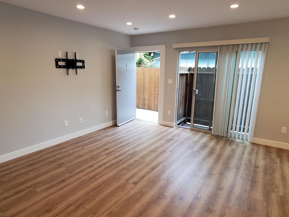 Brightly lit, large airy living room with luxury hard vinyl wood flooring with cork cushioning.