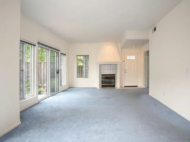 Living/family room. Front door entry is in the rt corner of this photo. Note fireplace and sliding doors to patio. South-facing windows.