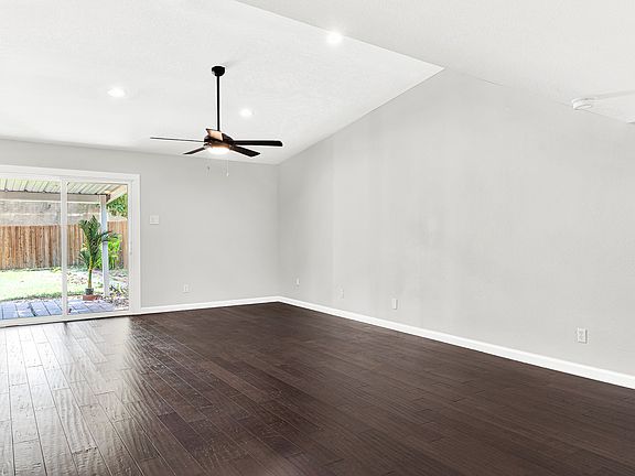 Large living room with high ceilings, engineered wood floors and access to the backyard.