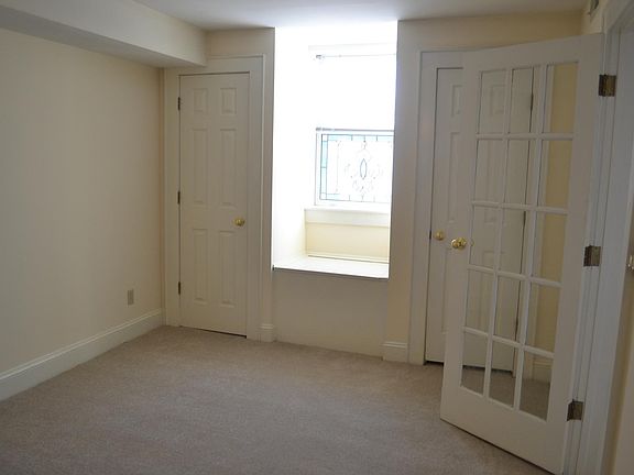 Bedroom with two closets and stained glade window seat. Glass door into living area.