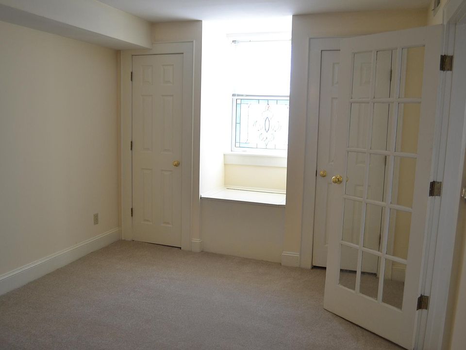 Bedroom with two closets and stained glade window seat. Glass door into living area.