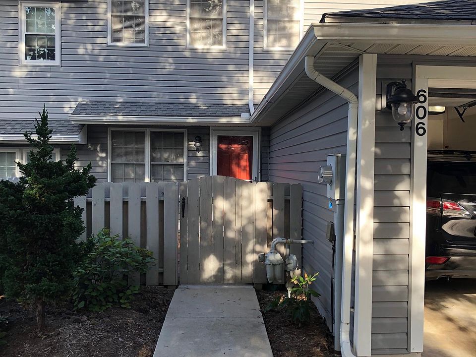 Front gated entrance with stone paved patio behind the gate.