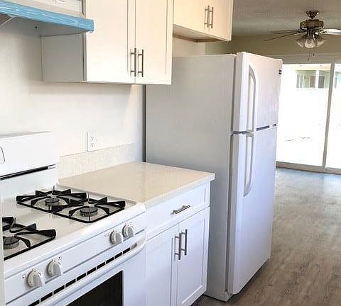 Kitchen with stove, range hood and refrigerator