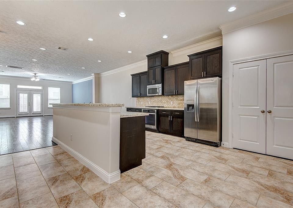 18x11 Kitchen - A spacious kitchen with granite counters, gas cooktop and a large pantry behind the doors on the right.