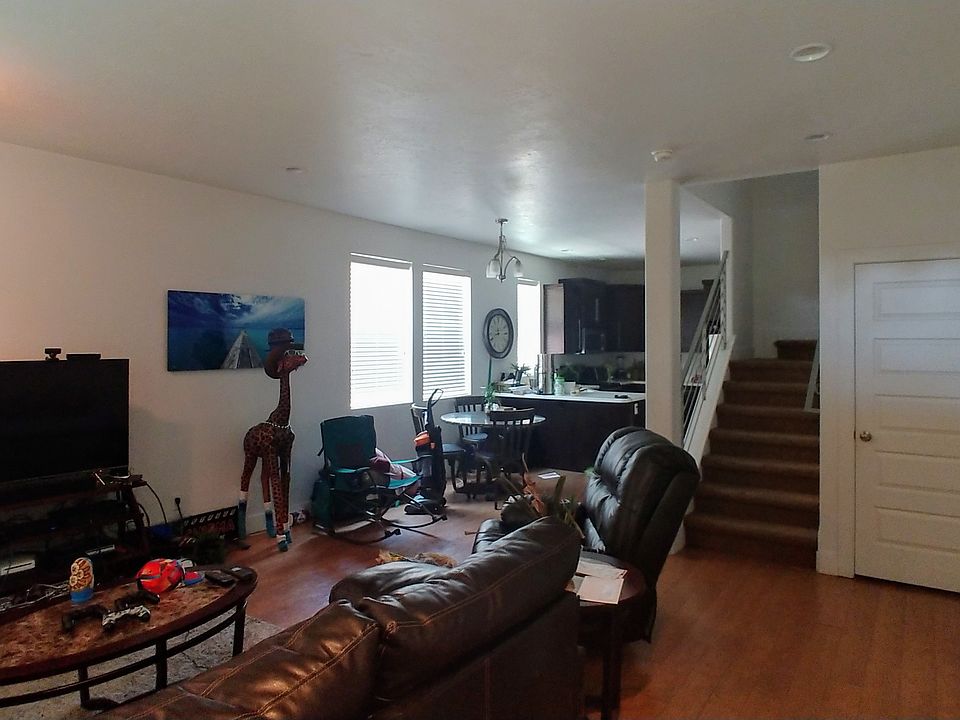 View from front door entry facing the living room, dining and kitchen areas. Stairway leads to the upstairs with 3 bedrooms and a loft area